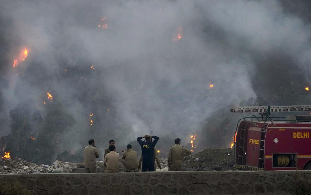 Các quan chức cứu hỏa tại đám cháy dữ dội ở bãi rác Bhalswa ở New Delhi, Ấn Độ. Ảnh: AP.