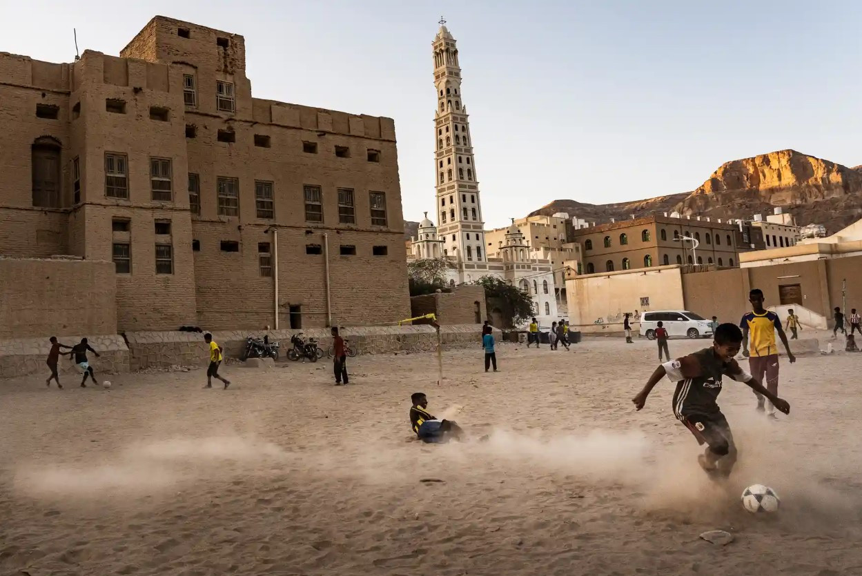 Một nhóm nam sinh chơi bóng vào lúc hoàng hôn ở Tarim, Hadhramaut. Ảnh: The Guardian.