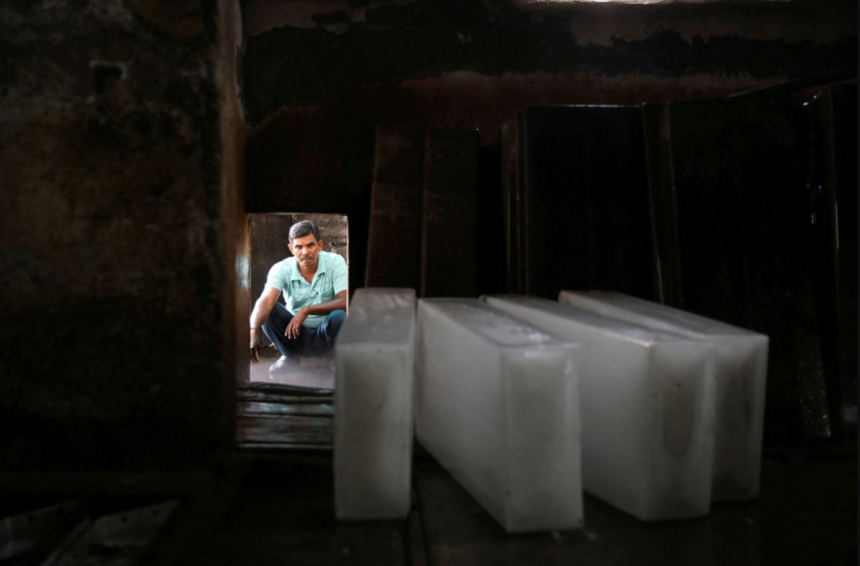 Một công nhân chờ xếp các khối đá lên xe tải tại một nhà máy nước đá trong một ngày hè nóng nực ở New Delhi, Ấn Độ. Ảnh: Reuters.