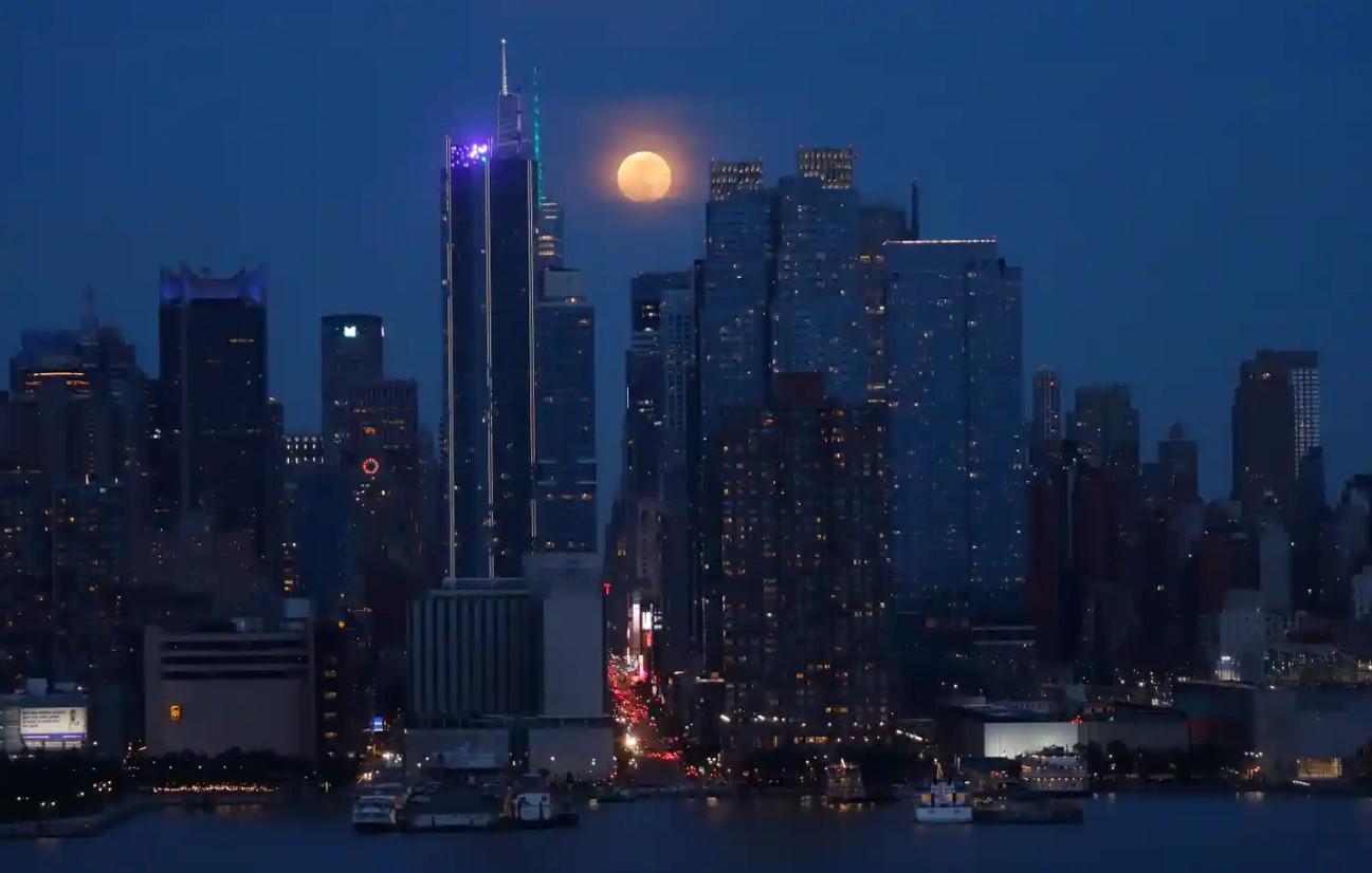 Mặt trăng phía sau đường chân trời của khu trung tâm Manhattan và Tòa nhà Empire State ở Thành phố New York, khi nhìn từ New Jersey. Ảnh: The Guardian.