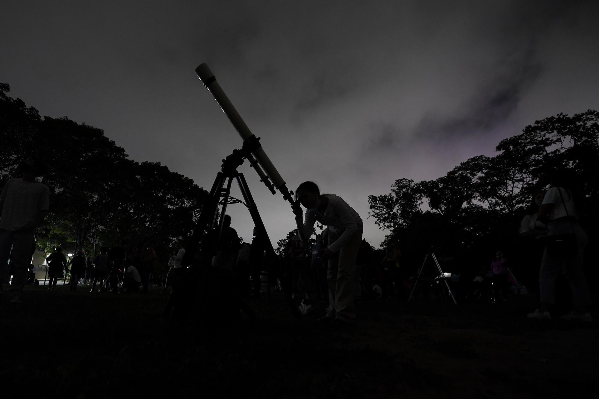 Một cô gái nhìn Mặt trăng qua kính viễn vọng trong kỳ trăng máu đầu tiên trong năm, ở Caracas, Venezuela. Ảnh: AP.