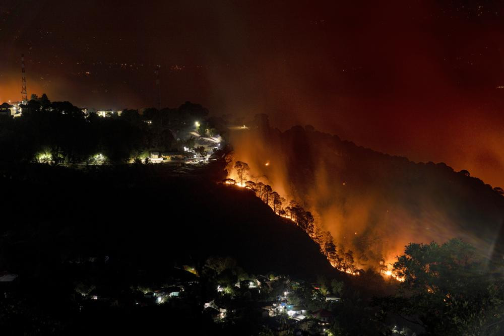 Một khu rừng trên sườn núi bốc cháy bên cạnh một thị trấn ở Dharmsala, Ấn Độ. Ảnh: AP.