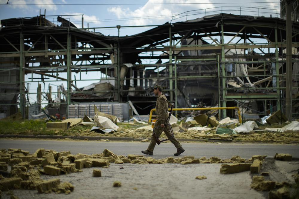 Một quân nhân Ukraine đi ngang qua một nhà máy sản xuất thạch cao bị phá hủy ở Bakhmut, miền Đông Ukraine. Ảnh: AP.