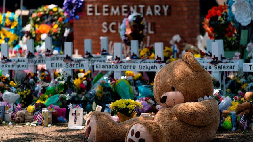 Một con gấu bông đặt trước cây thánh giá có tên của 21 nạn nhân thiệt mạng tại trường tiểu học Robb. Ảnh: CNN.