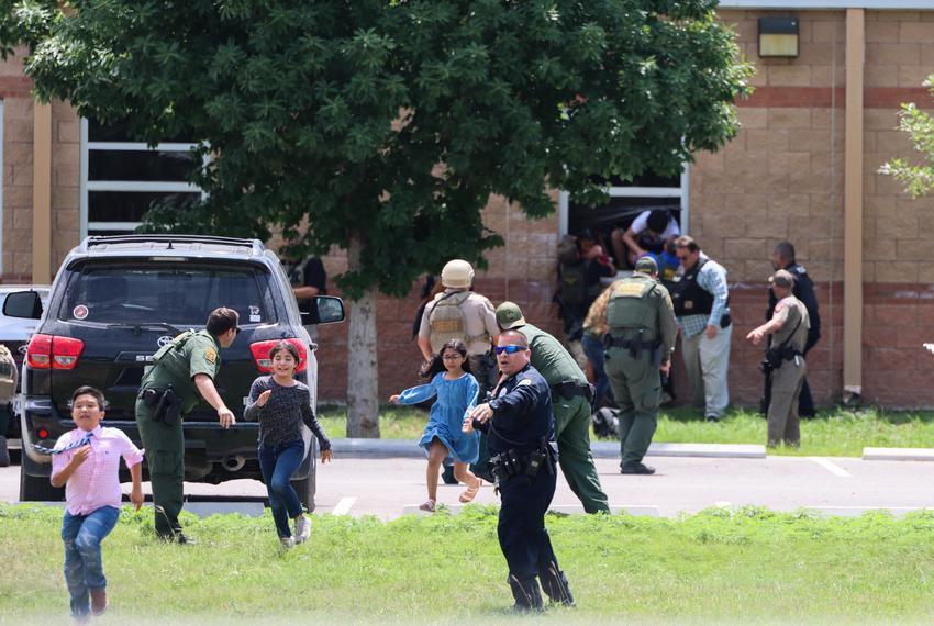 Học sinh chạy trốn và cảnh sát giúp những người khác sơ tán hôm 24/5 sau khi một tay súng vào trường tiểu học Robb ở Uvalde. Ảnh: NYT.