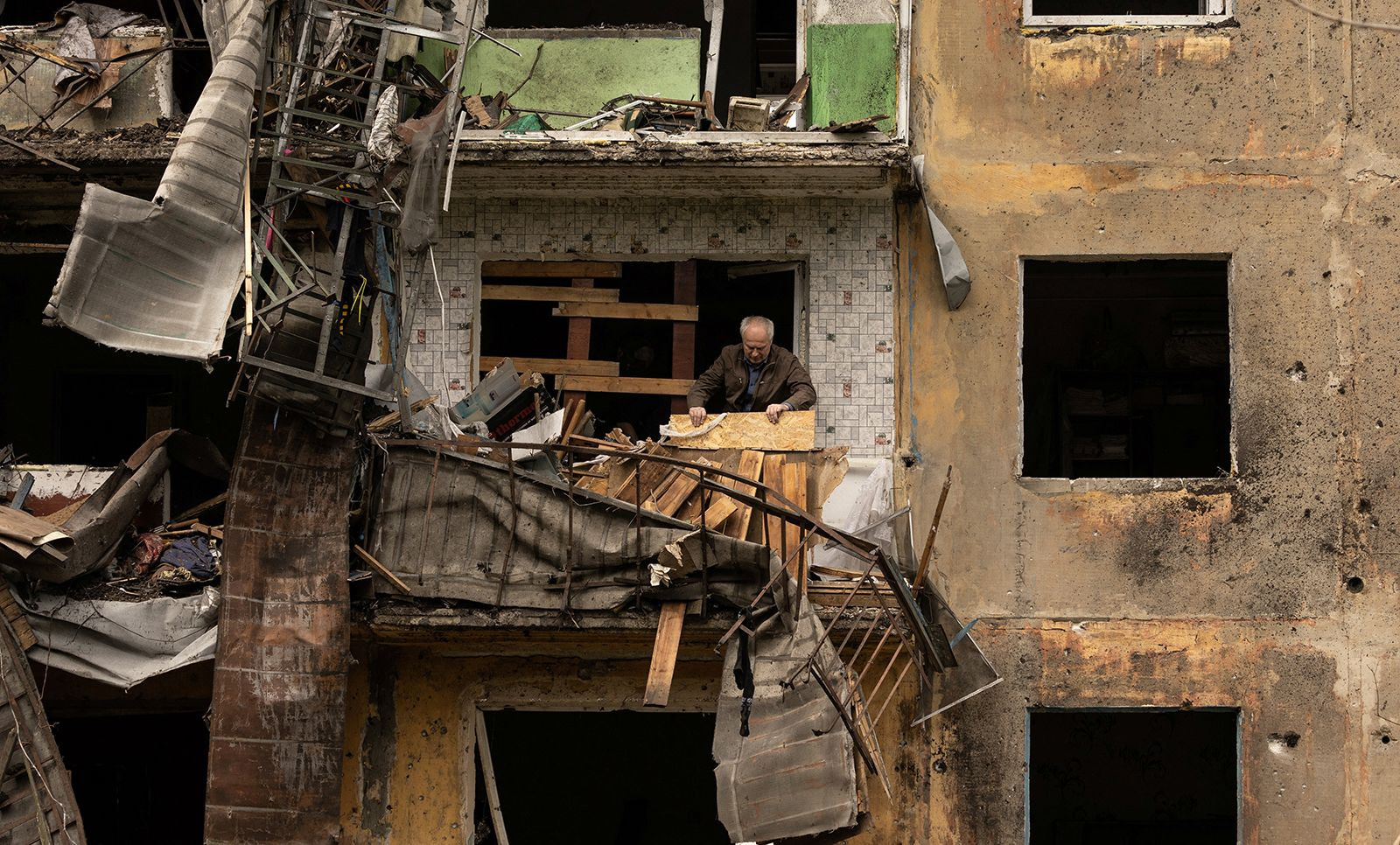 Một người đàn ông đứng trên ban công căn hộ ở vùng Donetsk, Ukraine. Ảnh: AP.