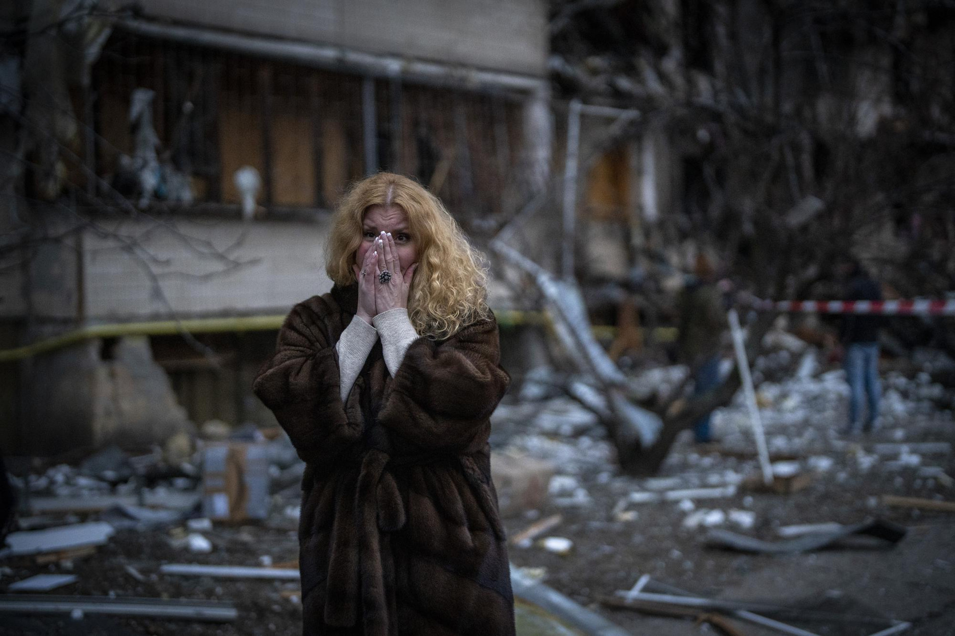 Một phụ nữ đứng tại nhà sau một vụ tấn công bằng tên lửa ở Kiev, Ukraine. Ảnh: AP.