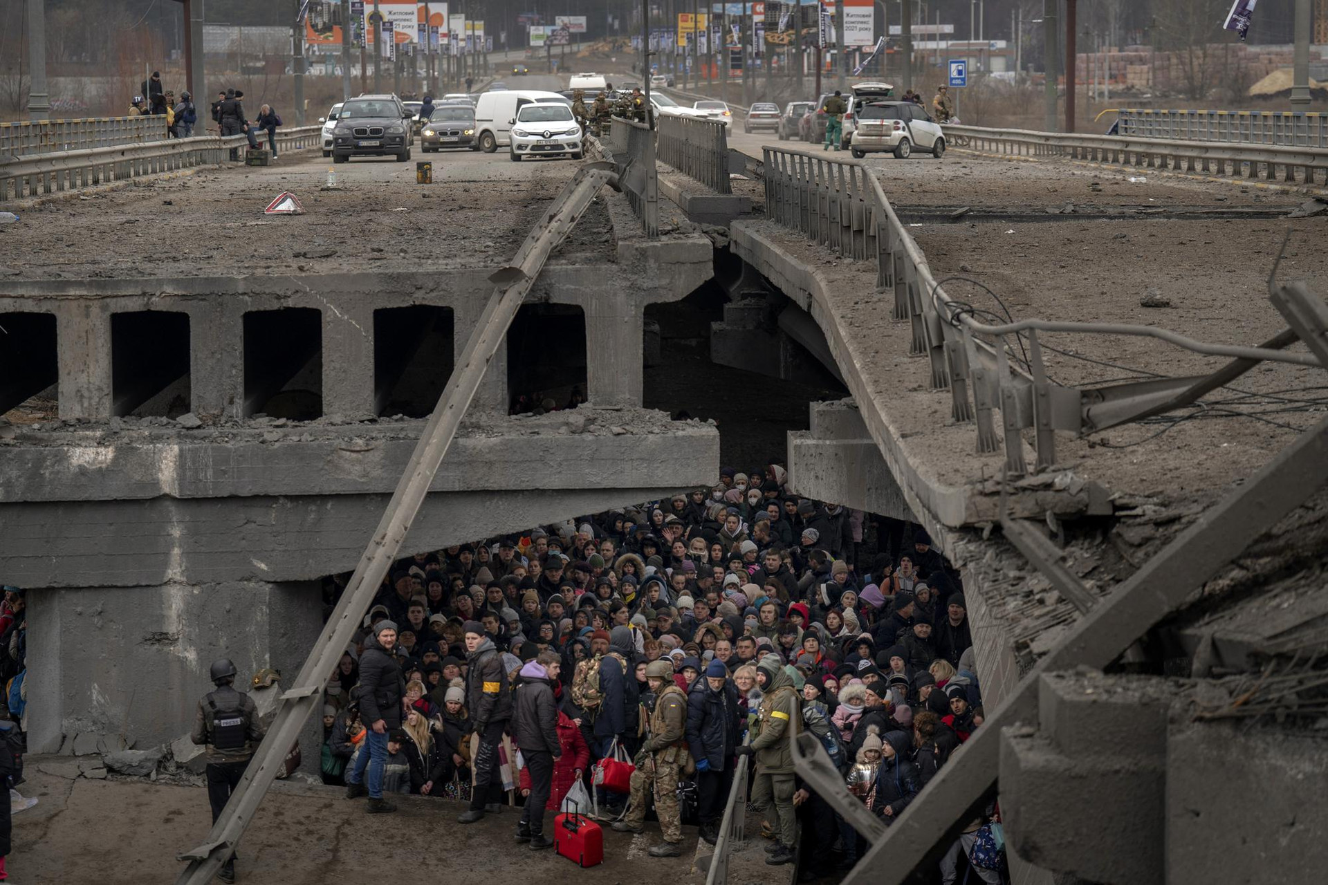 Người dân Ukraine tập trung dưới một cây cầu bị phá hủy khi họ cố gắng chạy trốn bằng cách băng qua sông Irpin ở ngoại ô Kiev, Ukraine. Ảnh: AP.