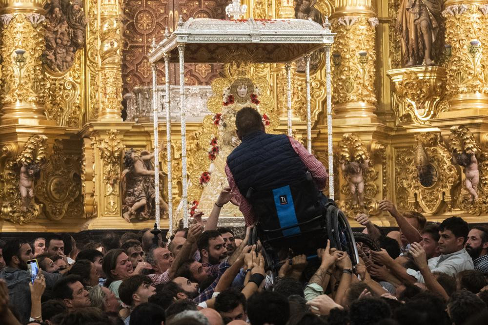 Một người đàn ông được nâng lên trước mặt Đức Trinh Nữ El Rocio trong đền thờ Đức mẹ đồng trinh ở làng El Rocio, gần Almonte, Tây Ban Nha. Ảnh: AP.