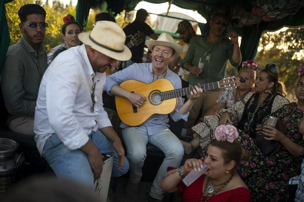 Những người hành hương hát trên đường đến đền thờ El Rocio ở Vado del Quema, gần Aznalcázar, Tây Ban Nha. Ảnh: AP.