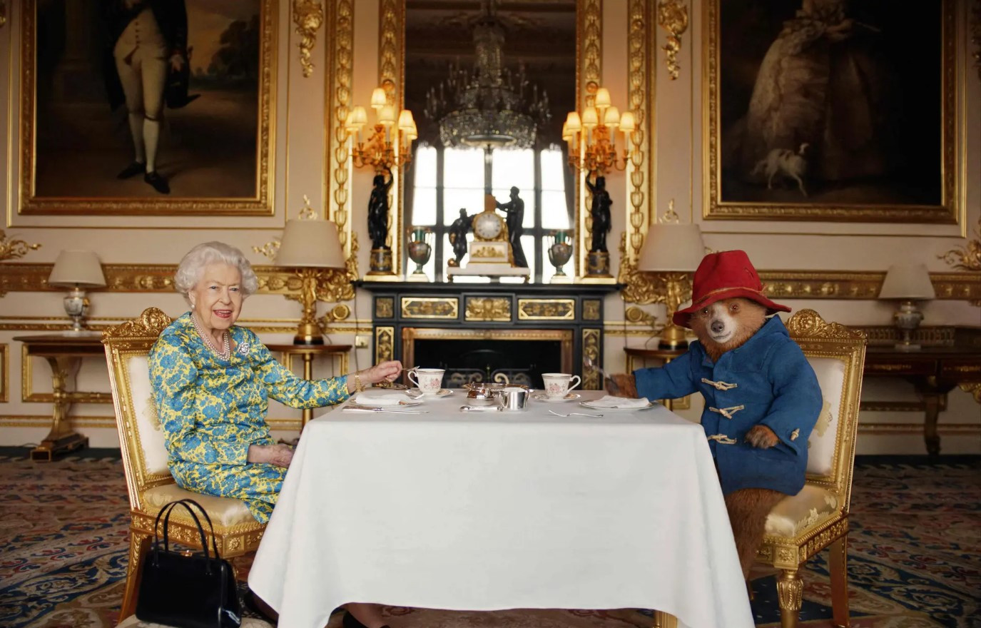 Nữ hoàng Anh và Gấu Paddington uống trà kem tại Cung điện Buckingham trong Bữa tiệc Bạch kim tại Cung điện. Ảnh: Cung điện Buckingham.