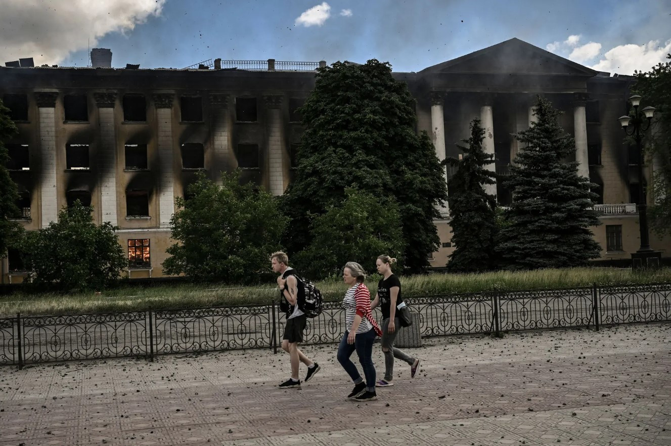 Người dân đi ngang qua một trường đại học đang cháy. Ảnh: Getty Images.