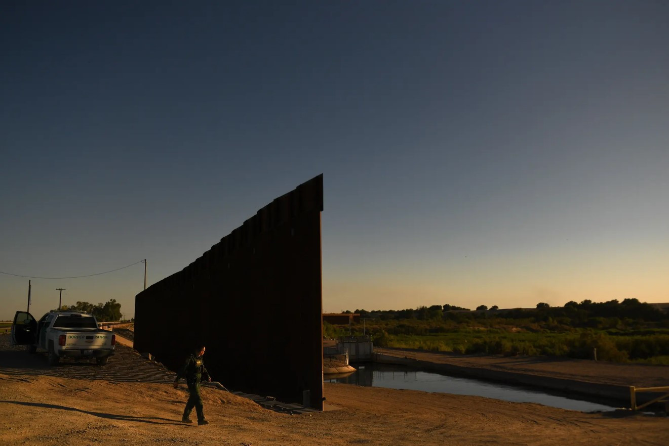 Một nhân viên tuần tra biên giới đi giữa khoảng trống dọc theo bức tường giữa Mỹ và Mexico, giữa vấn nạn di cư. Ảnh: Getty Images.