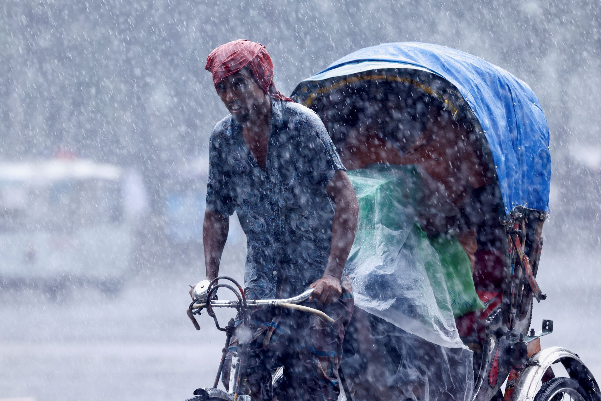 Một người đàn ông kéo xe giữa trận mưa lớn gây ra lũ lụt trên diện rộng ở Dhaka, Bangladesh. Ảnh: Reuters.