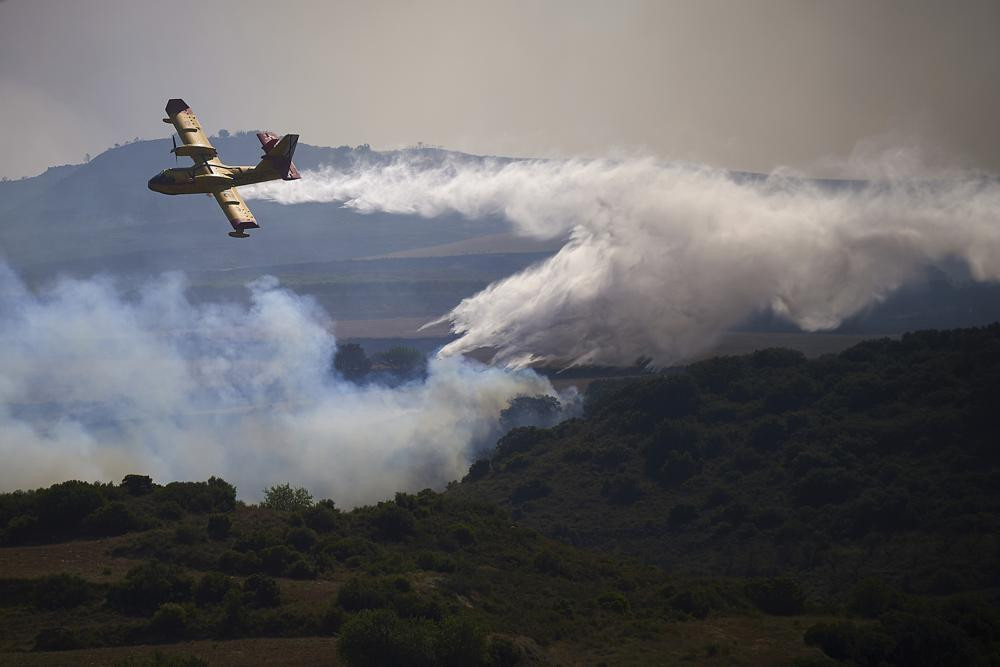 Một máy bay chữa cháy thả chất chống cháy xuống khu vực đang bốc cháy của San Martin de Unx ở miền Bắc Tây Ban Nha. Ảnh: AP.