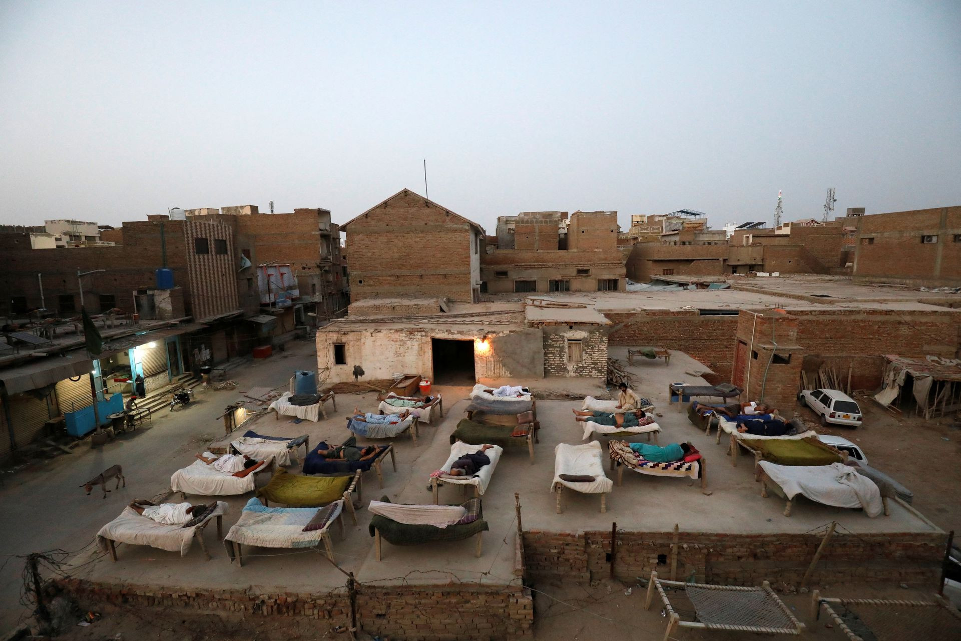 Những người đàn ông ngủ trên mái nhà ở Jacobabad vào sáng sớm. Ảnh: Reuters.