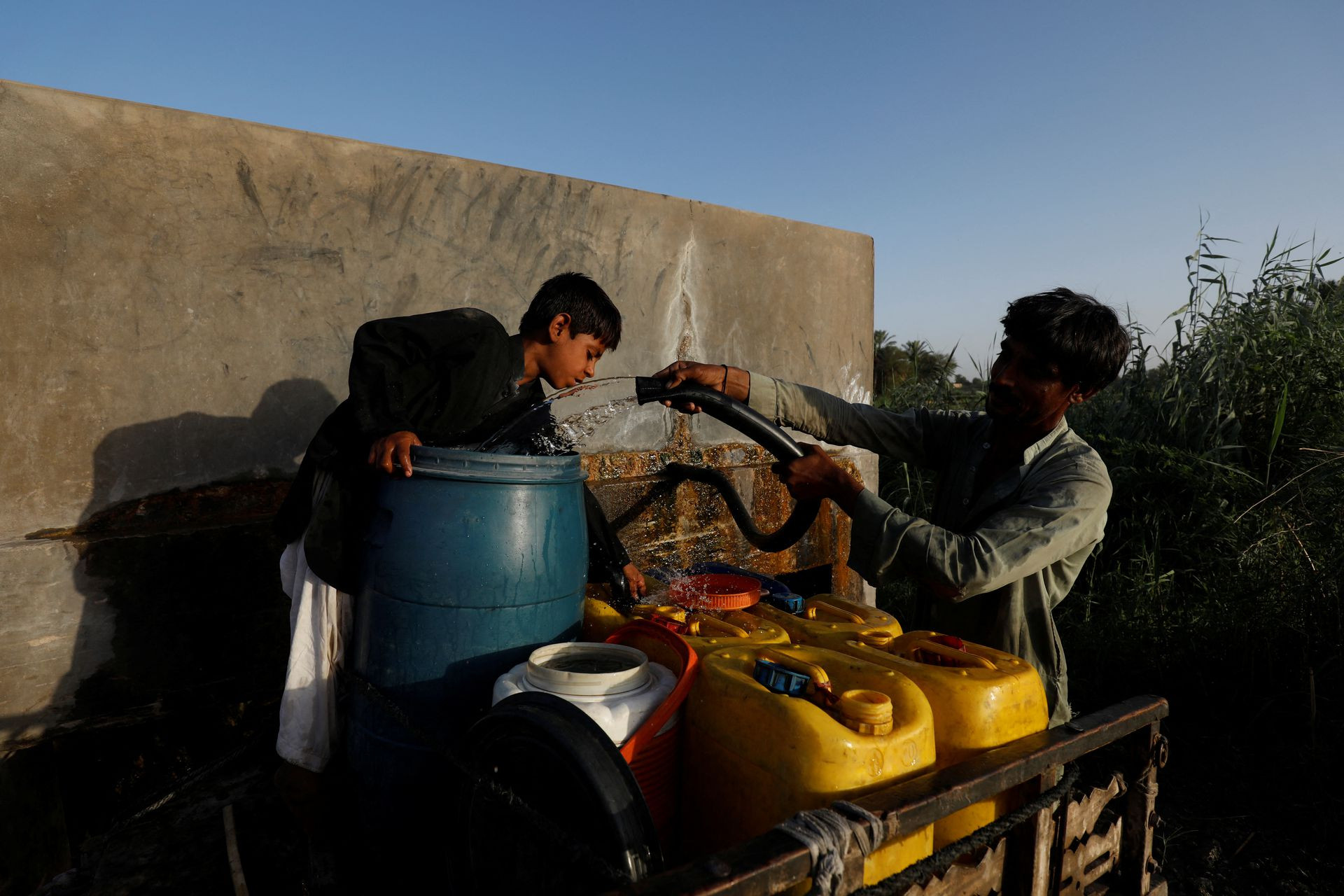 Người dân đổ đầy những thùng nước để đi bán cho các khu dân cư ở Jacobabad. Ảnh: Reuters.