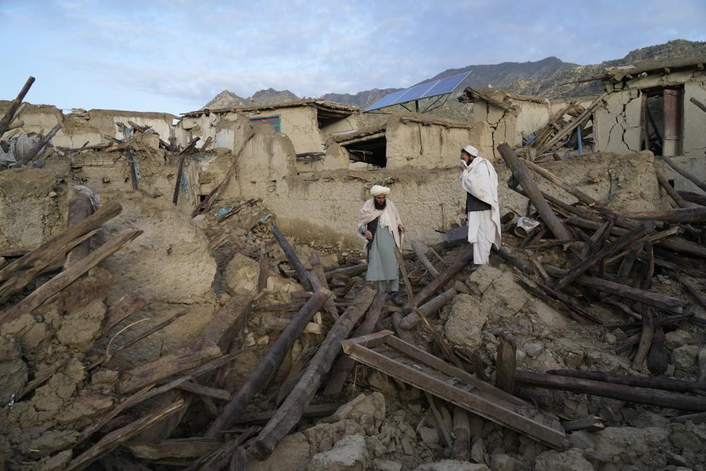 Người dân Afghanistan đứng giữa đống đổ nát sau trận động đất ở làng Gayan, thuộc tỉnh Paktika, Afghanistan. Ảnh: AP.