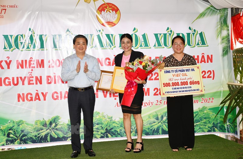 Chủ tịch UBMTTQ tỉnh Nguyễn Thị Hồng Nhung nhận kinh phí từ nhà tài trợ  và Bí thư Tỉnh ủy Lê Đức Thọ trao bằng khen và hoa cho nhà tài trợ