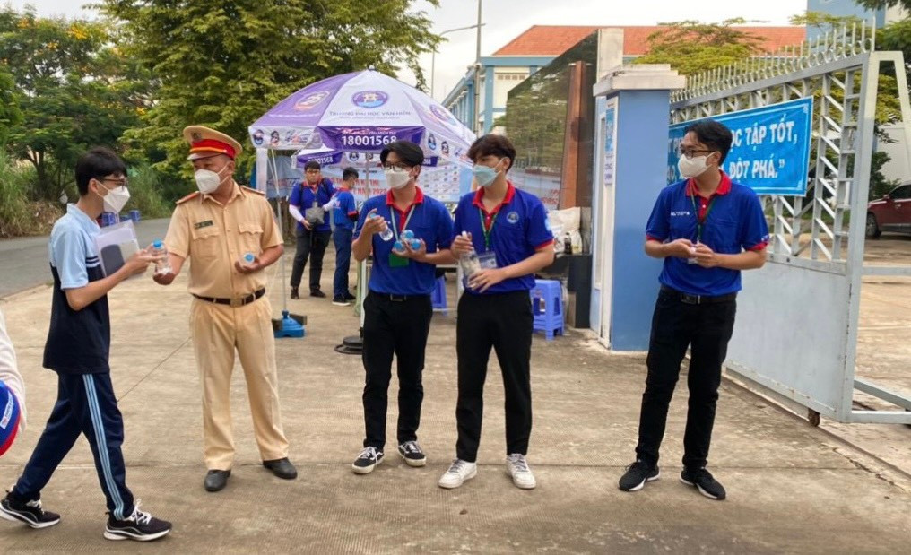 Cán bộ CGGT Trạm Đa Phước tặng nước suối cho thí sinh.