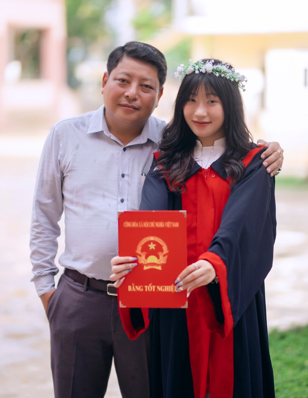 Em Lý Thùy Nhung chụp ảnh cùng bố của mình trong buổi tổng kết cuối năm học lớp 12 (Ảnh: NVCC).