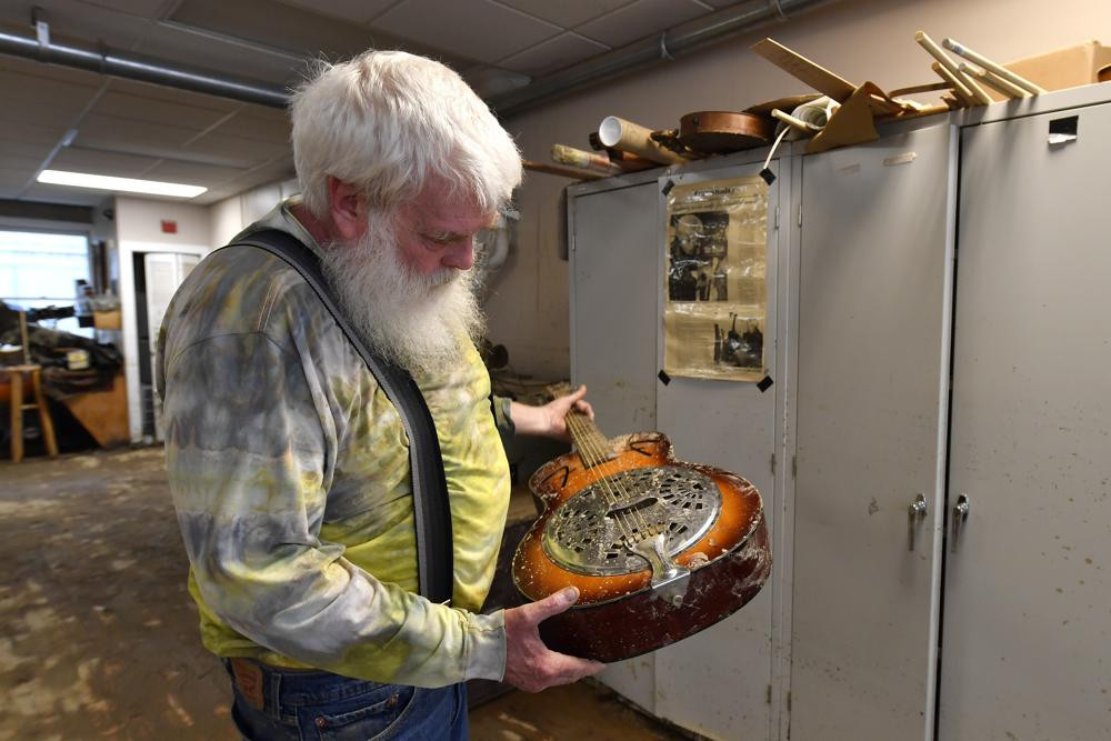 Paul Williams kiểm tra thiệt hại của một cây đàn guitar dobro bị hư hại do nước lũ từ Troublesome Creek tại xưởng và bảo tàng trường ở Hindman, Kentucky. Ảnh: AP.