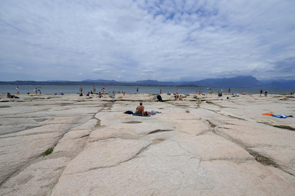 Mọi người tắm nắng trên bán đảo Sirmione, trên hồ Garda, Italy. Ảnh: AP.