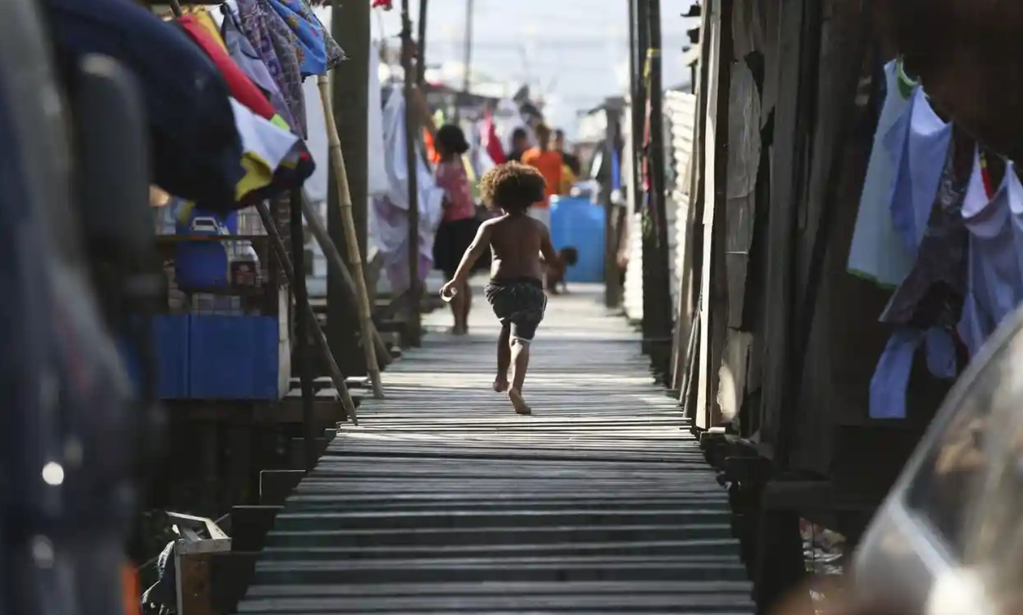Một cô bé chạy về nhà của mình ở Cảng Moresby. Ảnh: Aaron Favila / AP.