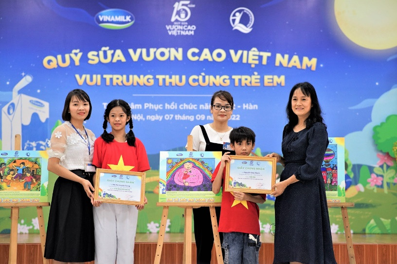 Em Phí Thị Huyền Trang (giải khuyến khích) và Nguyễn Duy Mạnh (giải ba) nhận quà từ đại diện công ty Vinamilk.
