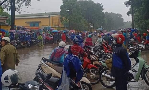 Dù mưa to nhưng hàng trăm công nhân đã nghỉ việc, tập trung trước cổng công ty vào sáng 1/10