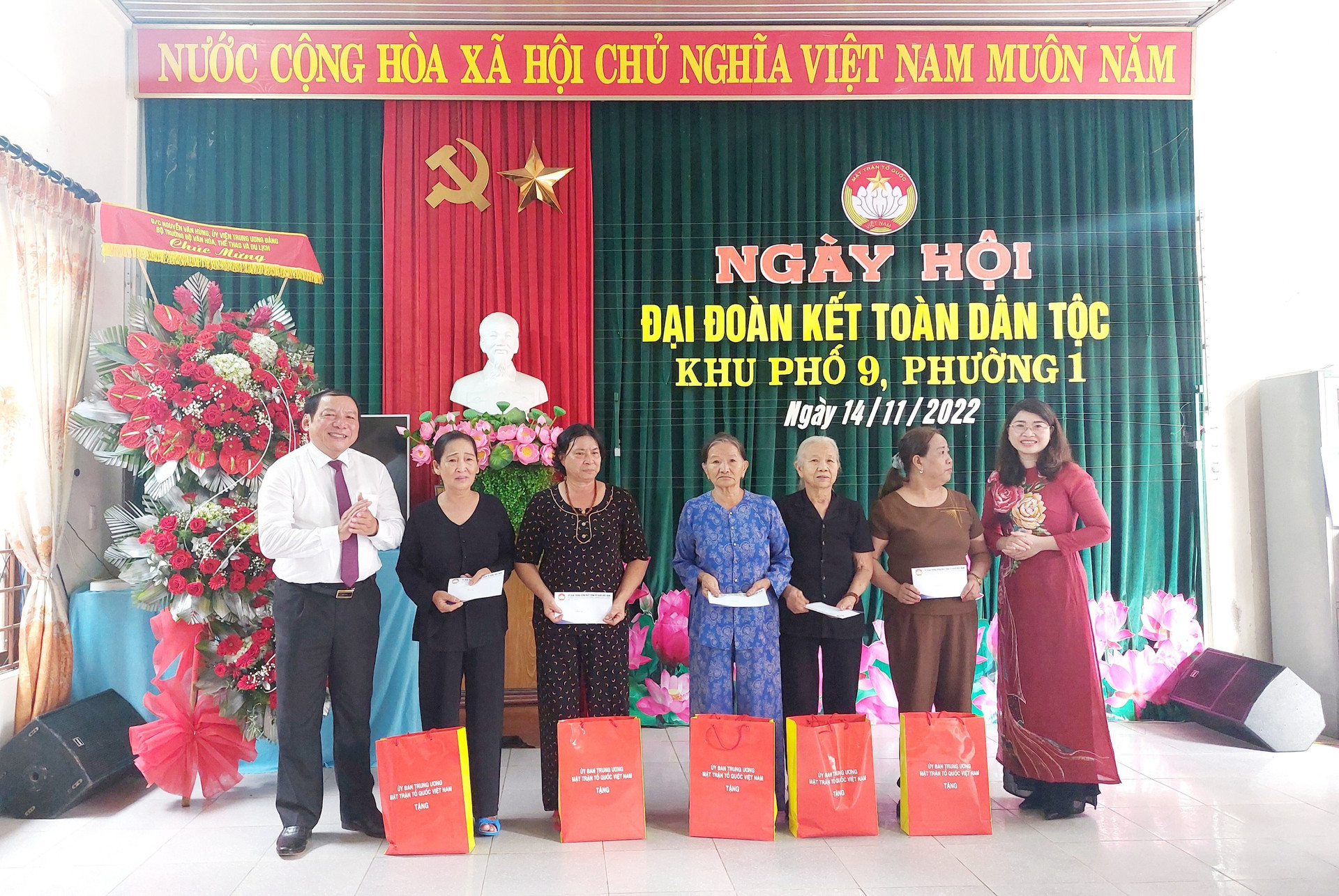 Ông Nguyễn Văn Hùng và bà Nguyễn Ngọc Quỳnh, Phó Trưởng ban Tôn giáo - Ủy ban Trung ương MTTQ Việt Nam (áo dài đỏ) trao quà các phần quà của Ủy ban Trung ương MTTQ Việt Nam đến người dân.