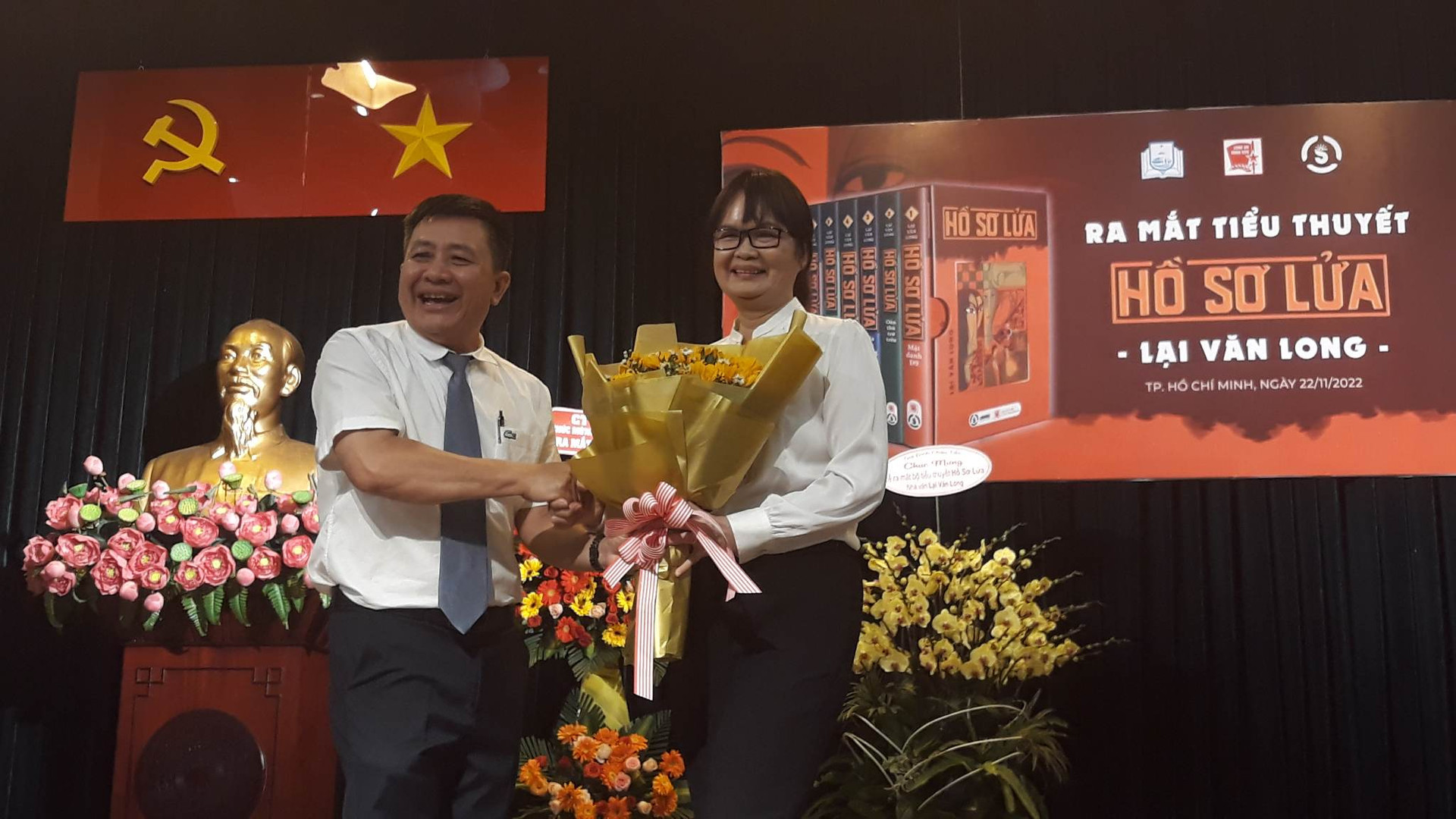 Nhà văn Trịnh Bích Ngân, Chủ tịch Hội Nhà văn TP HCM (bên phải ảnh) tặng hoa cho Nhà văn Lại Văn Long tại buổi lễ.