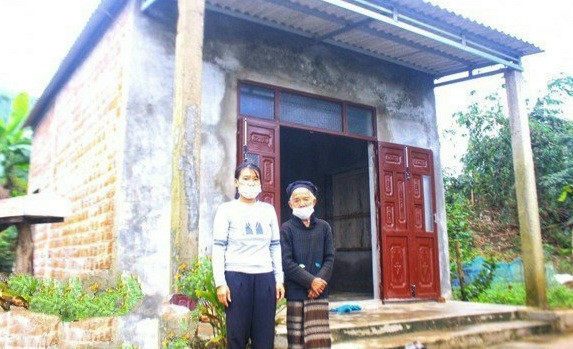 Mẹ con bà Hồ Căn Ta (xã Hướng Hiệp, huyện Đakrông) bên ngôi nhà Đại đoàn kết. Ảnh: Ủy ban MTTQ Việt Nam tỉnh Quảng Trị.