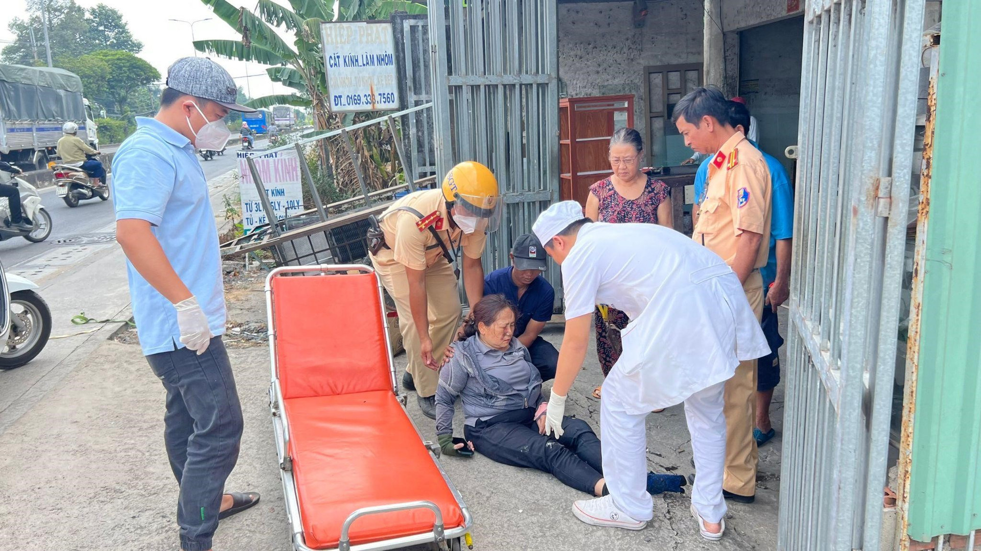 Đại uý Nguyễn Hoài Phong và trung tá Huỳnh Văn Hiếu, Phó trưởng trạm CSGT Tây Bắc hỗ trợ nạn nhân lên băng ca để vào bệnh viện cấp cứu.
