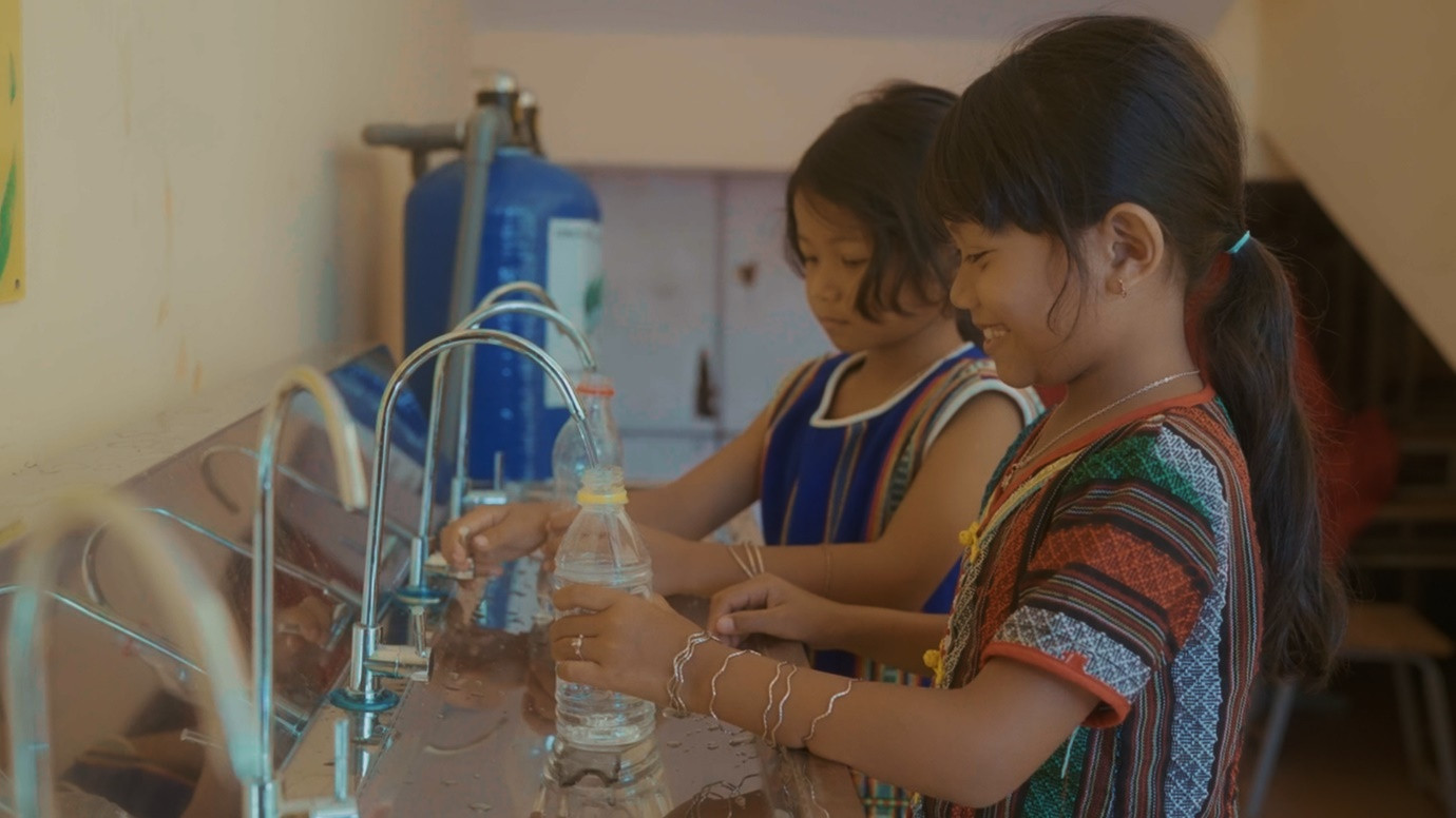 Niềm vui khi được sử dụng nguồn nước đạt chuẩn tại vòi của các em nhỏ tại huyện Bảo Lâm.