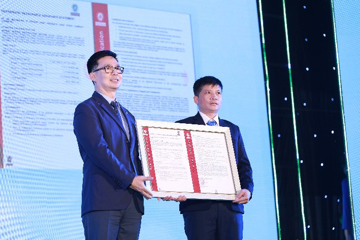 Đại diện Bureau Veritas (Anh Quốc) (trái) trao chứng nhận trung hòa carbon cho trang trại của Vinamilk tại Nghệ An.