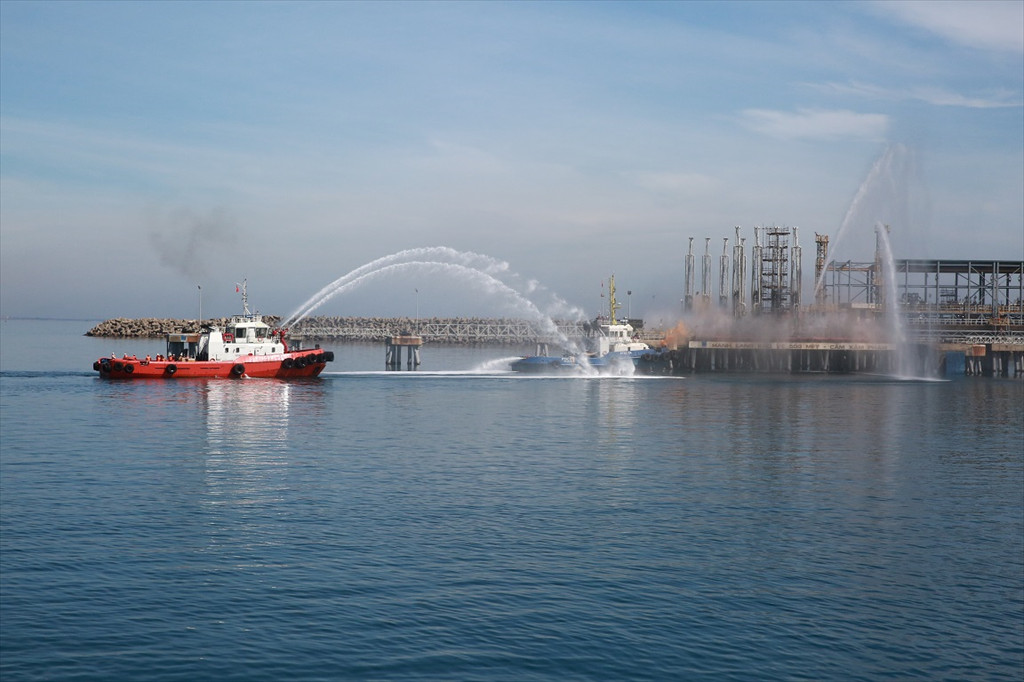 Các lực lượng chức năng tổ chức, phối hợp phun nước dập tắt đám cháy trên tàu va chạm vào khu vực cảng xuất sản phẩm của NMLD Dung Quất.