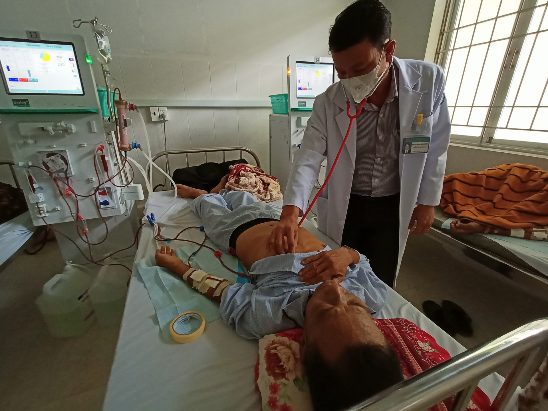 Bác sĩ Trịnh Hoà Đượm, Trưởng khoa Lọc máu, Bệnh viện Đa khoa Cái Nước thăm khám cho bệnh nhân mắc bệnh suy thận đang lọc máu tại đơn vị.