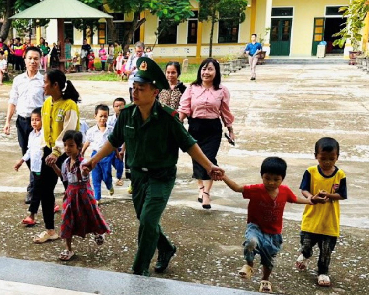 Cán bộ chiến sĩ Đồn Biên phòng Thanh đưa các em học sinh đến trường dự khai giảng năm học mới.