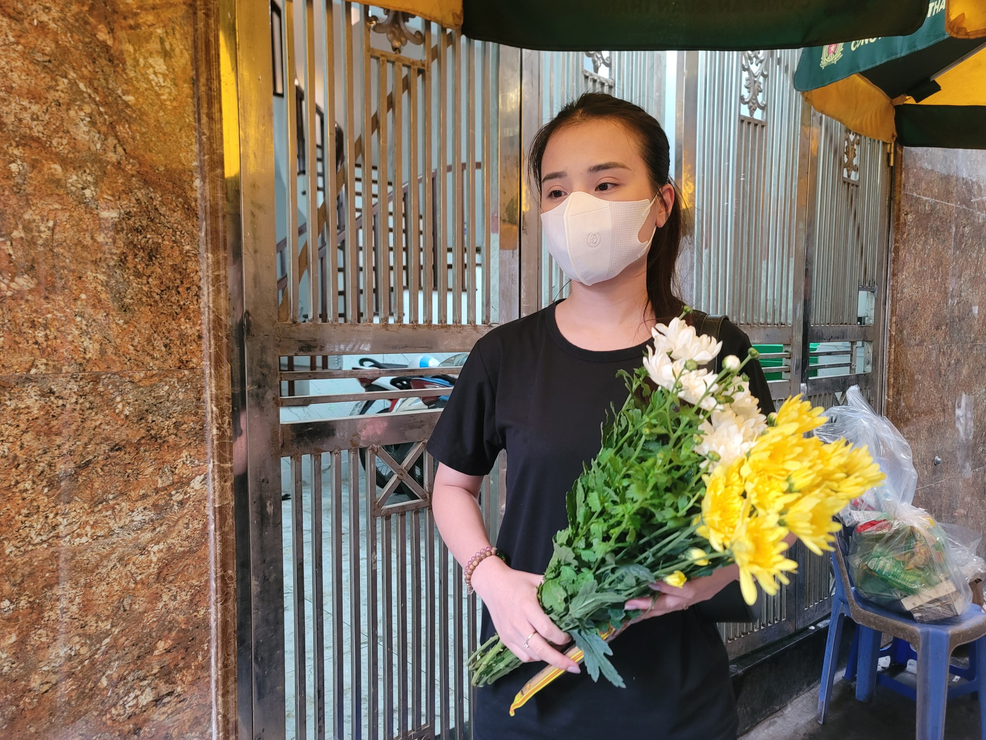Chị Hải Ngọc (29 tuổi, ở Tây Mỗ, Từ Liêm, Hà Nội) mang hoa cúc vàng, cúc trắng đến tưởng niệm các nạn nhân cháy chung cư mini.