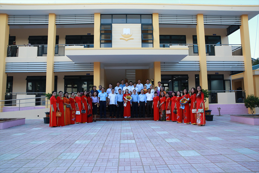 Lãnh đạo Huyện ủy, UBND huyện Bình Sơn; Công ty BSR và tập thể giáo viên nhà trường chụp ảnh lưu niệm trước sảnh công trình.