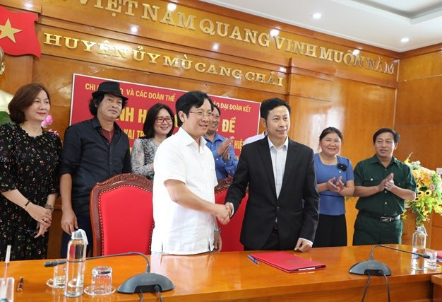 Đại diện Báo Đại Đoàn Kết và Ủy ban MTTQ huyện Mù Cang Chải ký Hợp tác thông tin tuyên truyền. Ảnh: Ngô Hùng.
