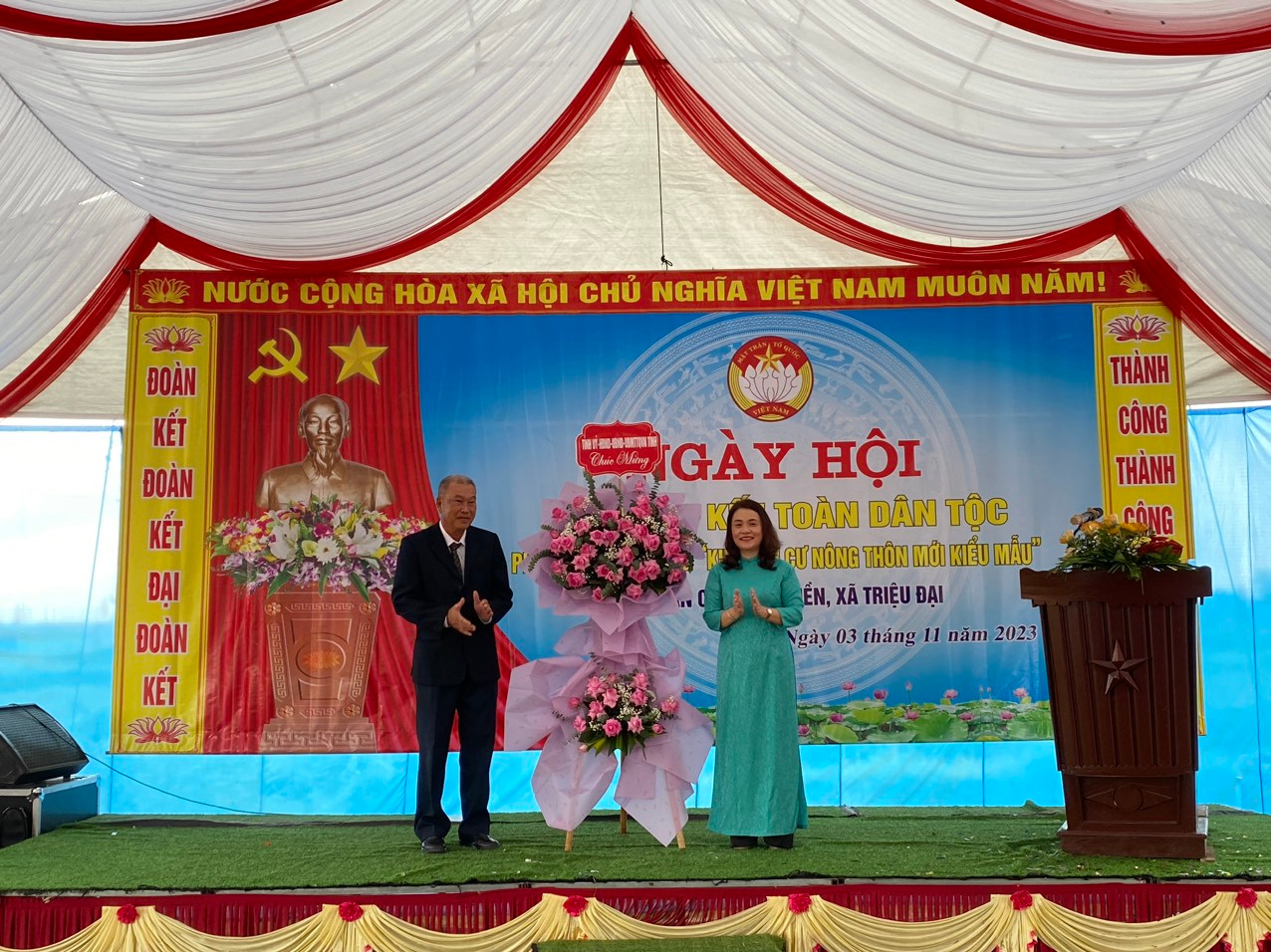 Bà Hồ Thị Thu Hằng thay mặt lãnh đạo tỉnh tặng hoa chúc mừng Ngày hội tại KDC Quảng Điền.