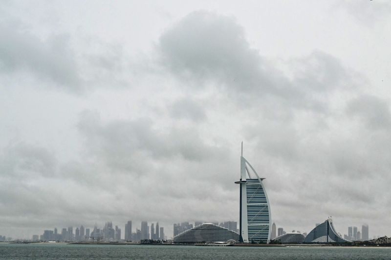 Thick clouds fill the sky above the Burj Al-Arab tower in Dubai on May 2, 2024, as heavy rains returned to the United Arab Emirates just two weeks after record downpours.
