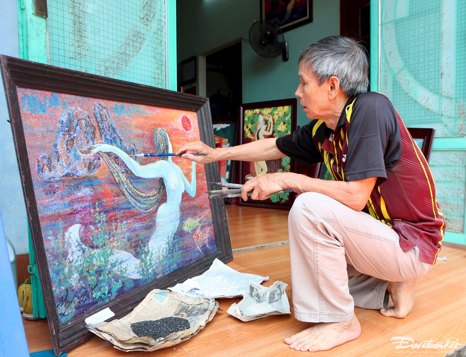 Hoạ sĩ Nguyễn Hiệp đang kiểm tra lớp than và điệp trên tác phẩm của mình