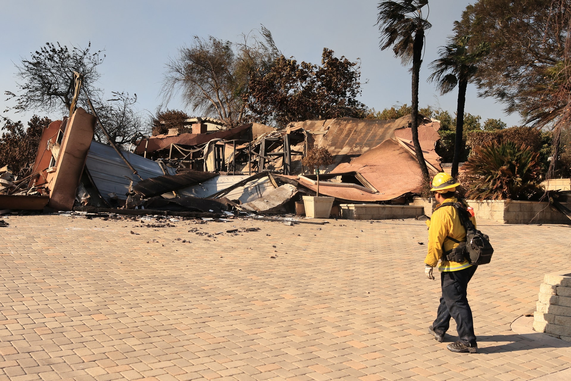 A person looks at a damaged house due to the Mountain Fire in Camarillo, California