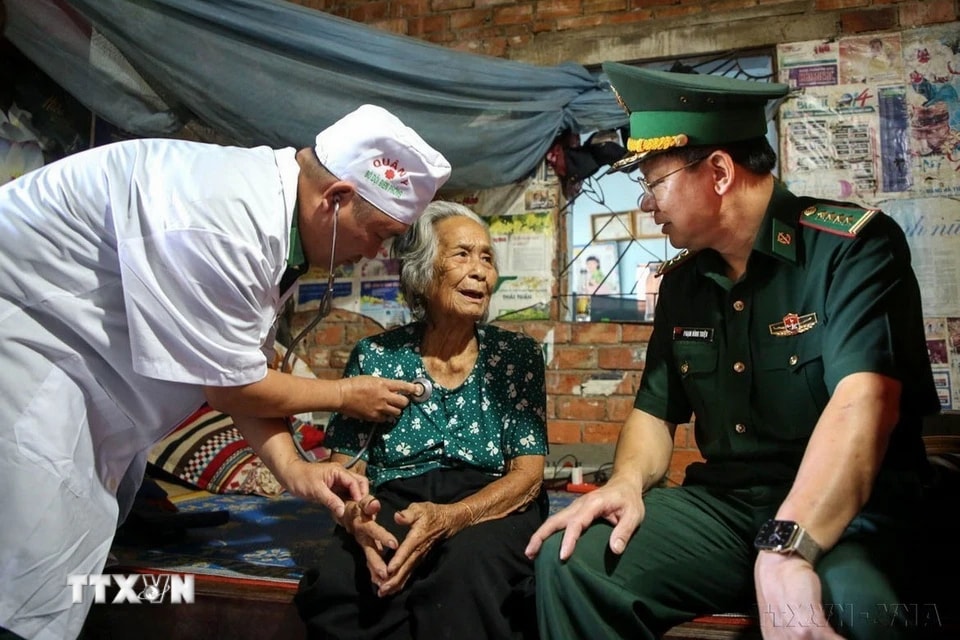 Cụ Đặng Thị Thang (84 tuổi, ngụ ấp Tân Hoà, xã Tân Lập) bày tỏ niềm vui với Đại tá Phạm Đình Triệu, Chính uỷ Bộ đội Biên phòng tỉnh Tây Ninh khi đến nhà thăm hỏi ngày Tết. (Ảnh: Giang Phương/TTXVN)
