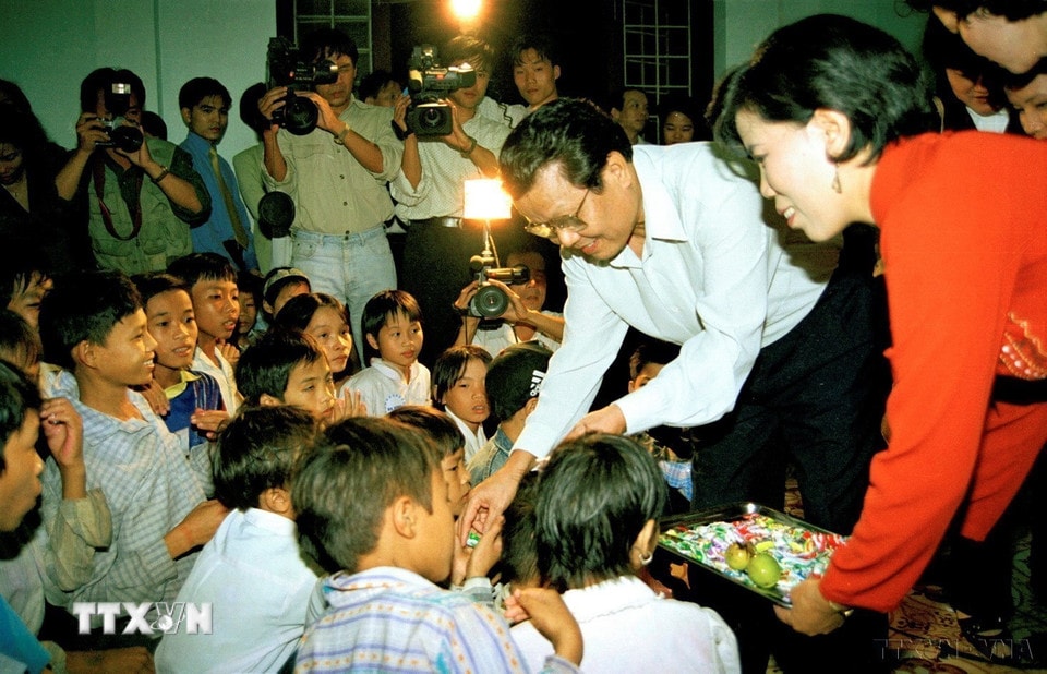 Chủ tịch nước Trần Đức Lương vui tết Trung thu và tặng quà cho các cháu có hoàn cảnh khó khăn, mồ côi được nuôi dậy tại các cơ sở mái ấm tình thương ở các quận, huyện của thành phố Hà Nội (5/10/1998). (Ảnh: Trọng Nghiệp/TTXVN)