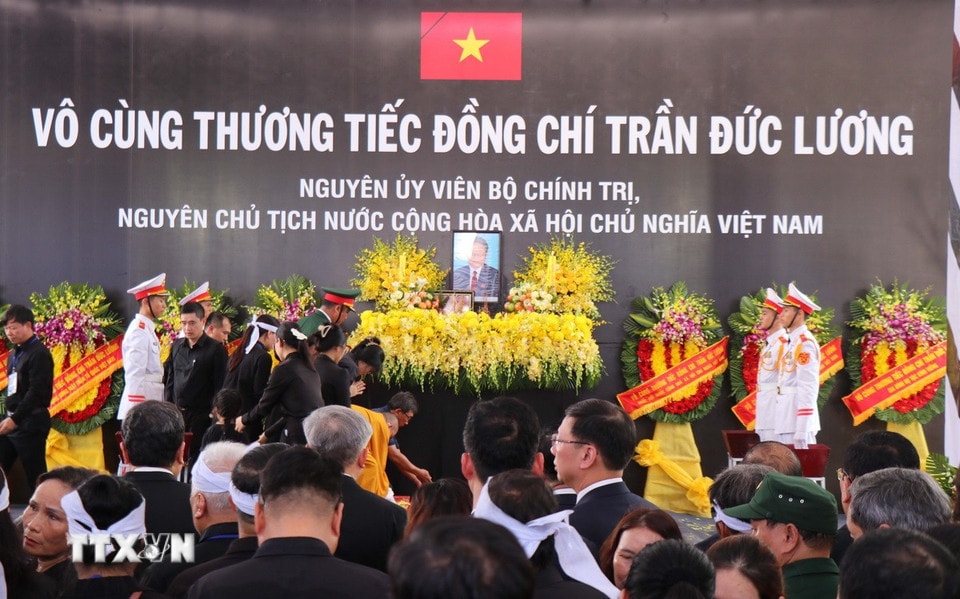 Nghi lễ thả hoa vào huyệt. (Ảnh: Phạm Cường/TTXVN)