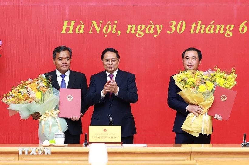 Thủ tướng Phạm Minh Chính trao quyết định và tặng hoa chúc mừng đồng chí Trần Đức Thắng (phải), Phó Tổng Thanh tra Thường trực Thanh tra Chính phủ và đồng chí Hồ Văn Niên, Thứ trưởng Thường trực Bộ Dân tộc và Tôn giáo. (Ảnh: Dương Giang/TTXVN)